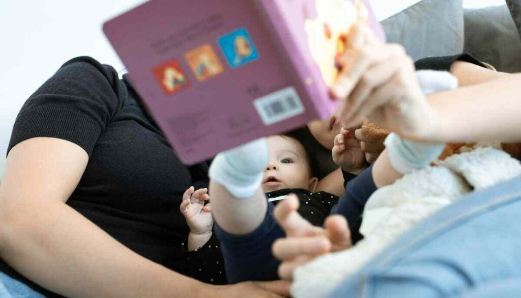 a woman reading a book to a baby